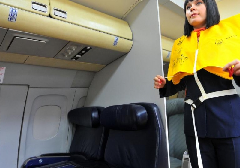 Спасательный жилет в самолете. Стюардесса спасательные жилеты. Спасательные жилеты на борту самолёта. Спасательный жилет под креслом в самолете.